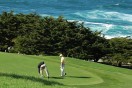 two golfers on the green at an oceanside golf course